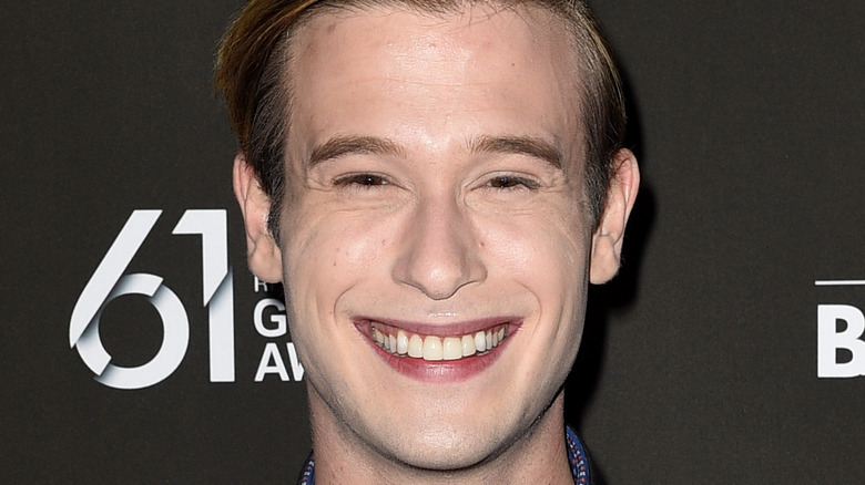 Tyler Henry in a leather jacket with a big smile