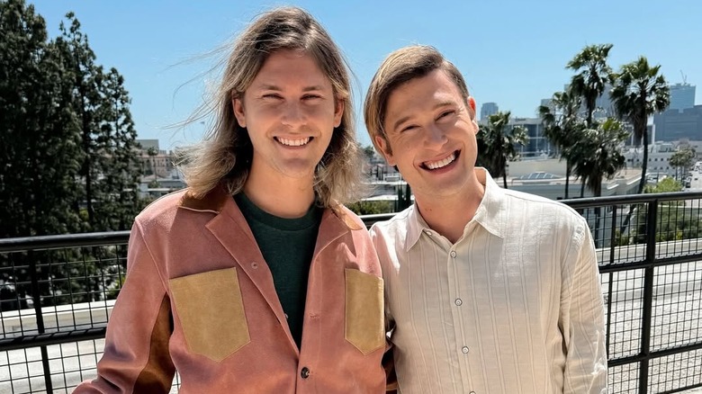 Tyler Henry and Clint Godwin smile outside a court house on their wedding day.