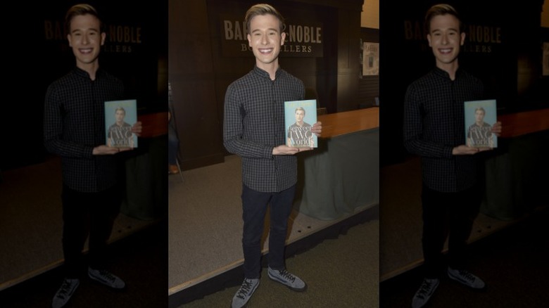 Tyler Henry smiling with his book at Barnes & Noble