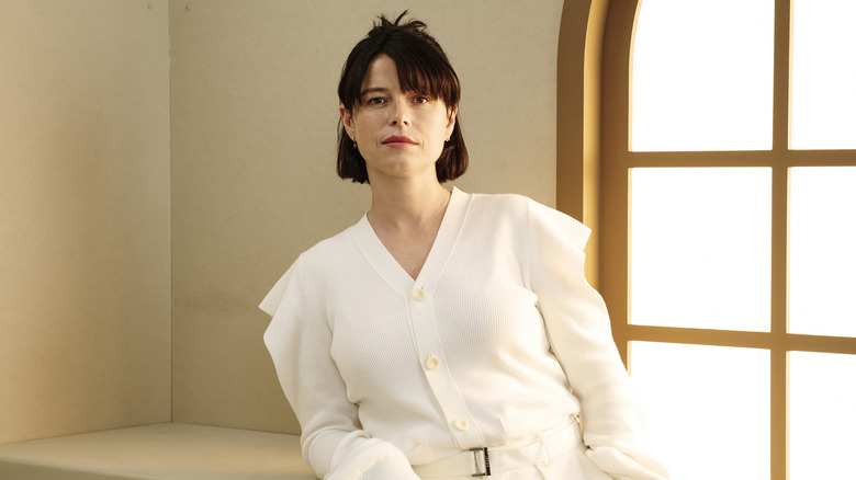 Jessie Buckley posing against a window