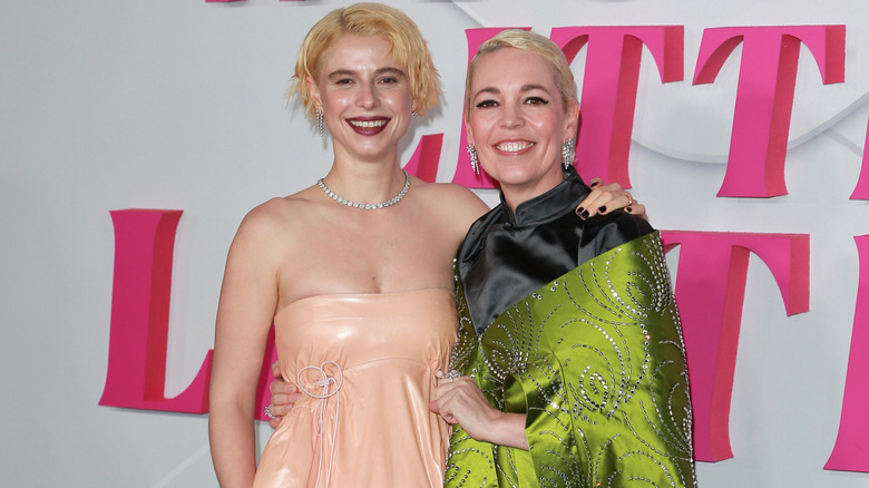 Jessie Buckley and Olivia Colman smiling on step-and-repeat