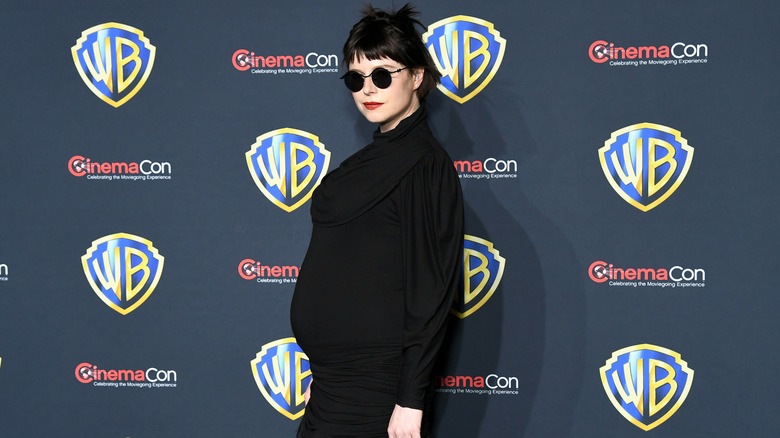 A pregnant Jessie Buckley posing on step-and-repeat