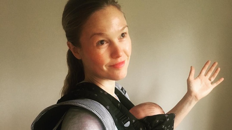 Julia Stiles arm out with baby