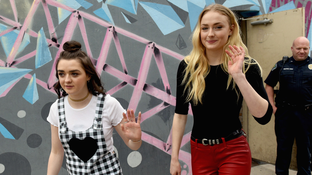 Maisie Williams and Sophie Turner waving to cameras