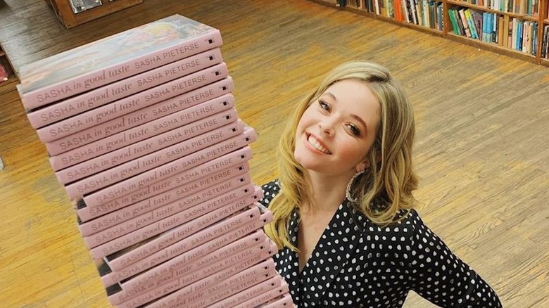 Sasha Pieterse with a stack of her books