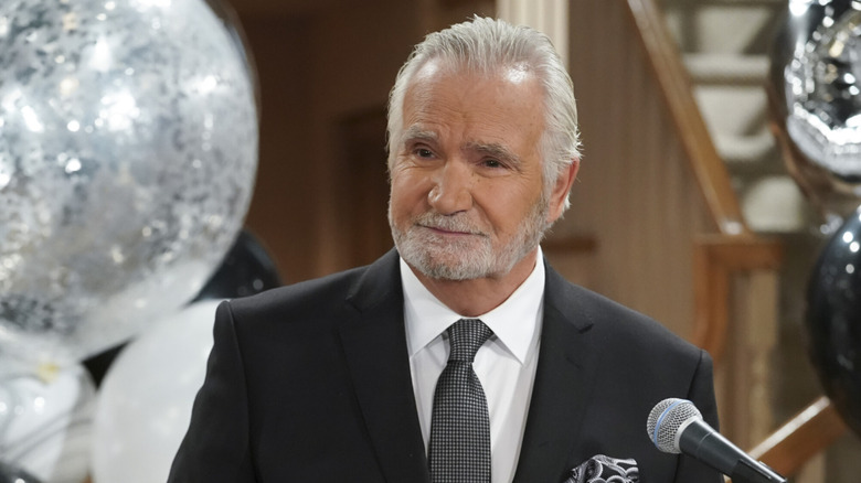 John McCook standing at a microphone