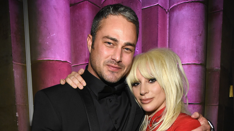 Taylor Kinney and Lady Gaga wrapping their arms around each other