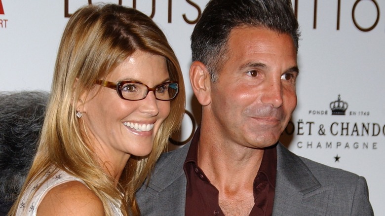 Lori Loughlin wearing glasses and Mossimo Giannulli on a red carpet together