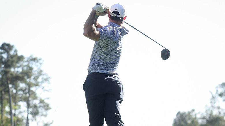 A rear view of Rory McIlroy holding his golf club