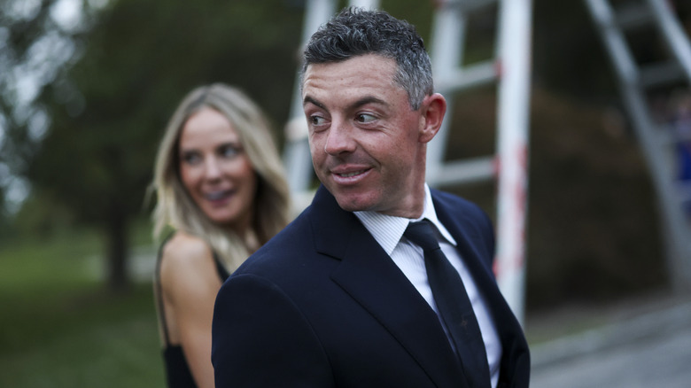 Rory McIlroy in front of Erica Stoll
