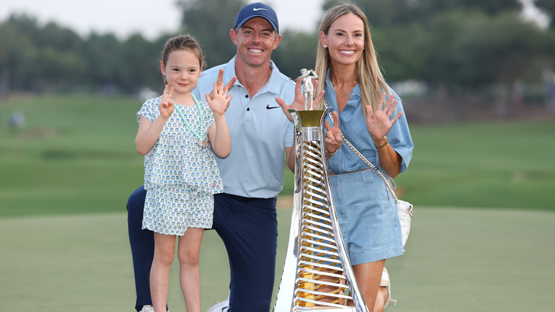 Poppy McIlrory, Rory McIlroy, and Erica Stoll with a trophy