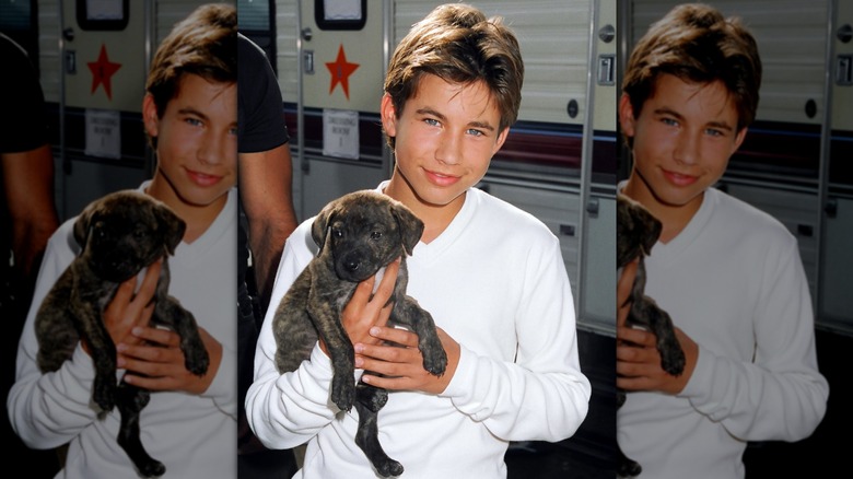 Jonathan Taylor Thomas poses with a puppy at a Nickelodeon charity event in 1996