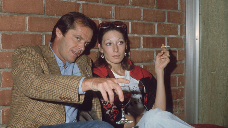 Jack Nicholson and Anjelica Huston sitting next to each other