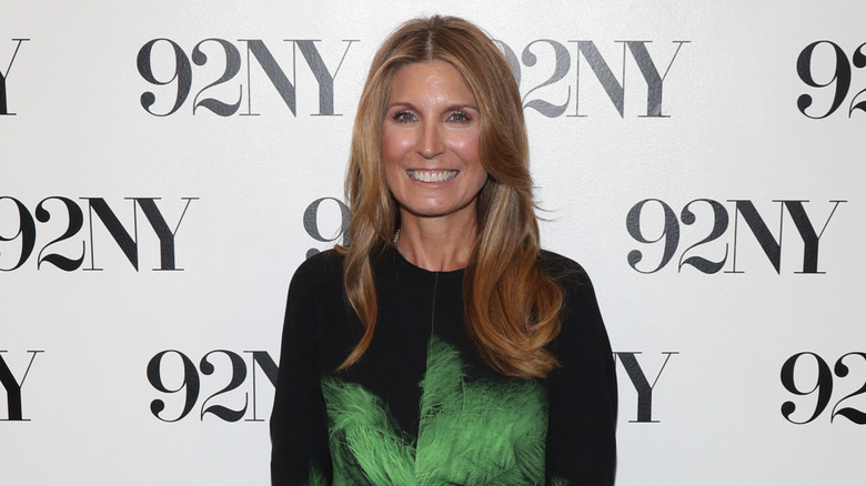 Nicolle Wallace smiling at an event in a black and green dress