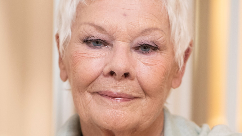 Dame Judi Dench poses on the red carpet in white