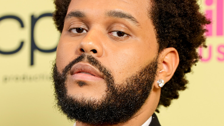 The Weeknd with facial hair and diamond earring