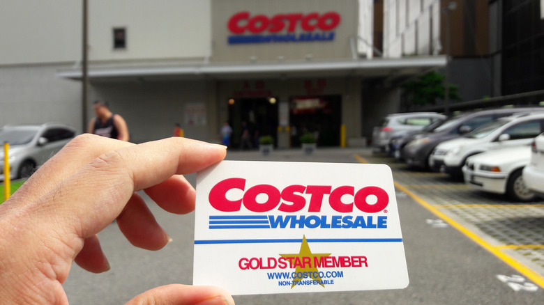 Hand holding Costco card outside of Costco