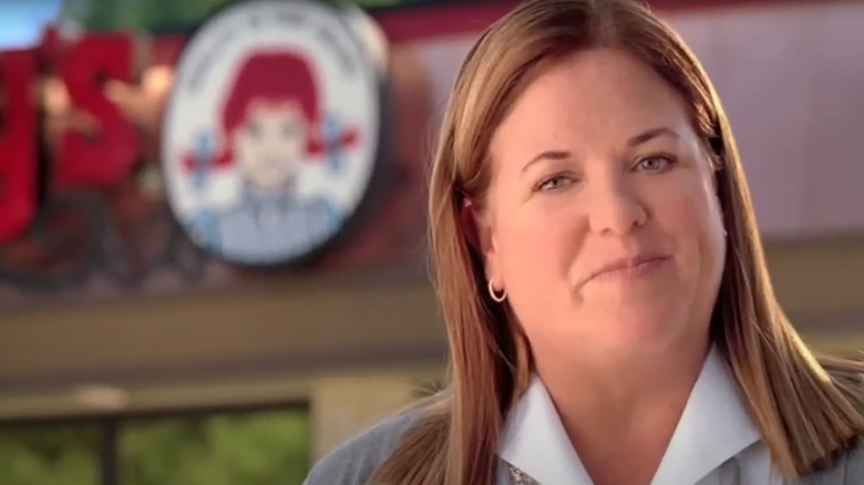 Wendy Thomas in front of out-of-focus Wendy's restaurant