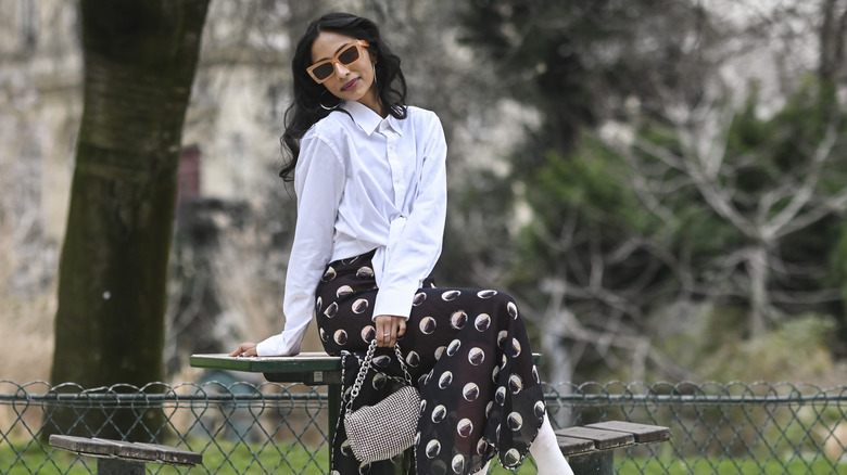 Woman wearing white button-down shirt and a skirt