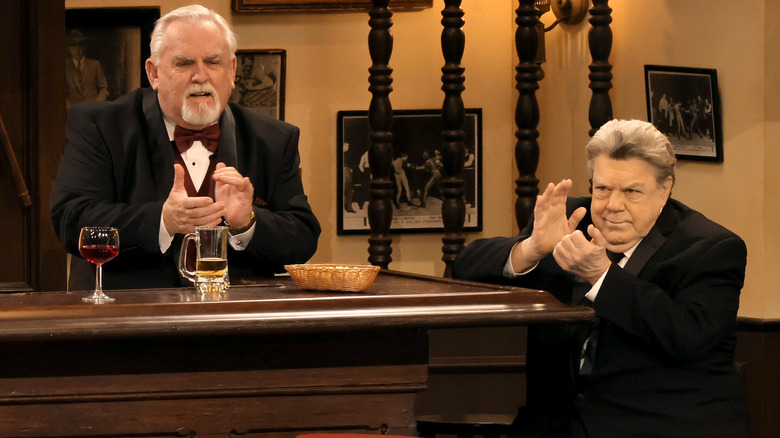 John Ratzenberger stands behind bar, George Wendt sits at bar