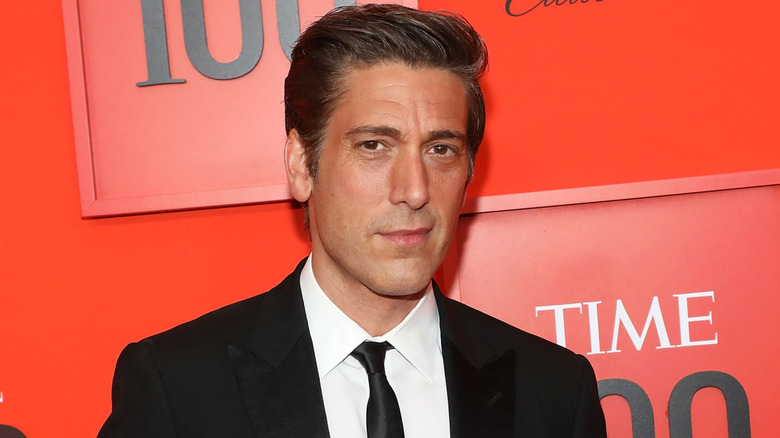 David Muir posing for the camera in a black suit at the TIME 100 Gala