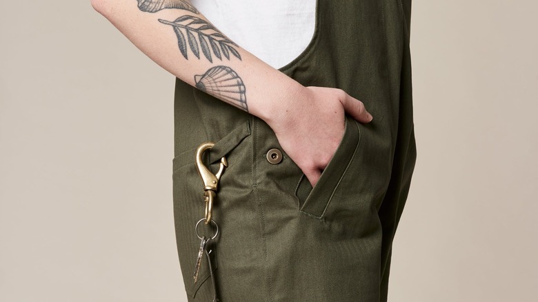 Tattooed woman in green overalls