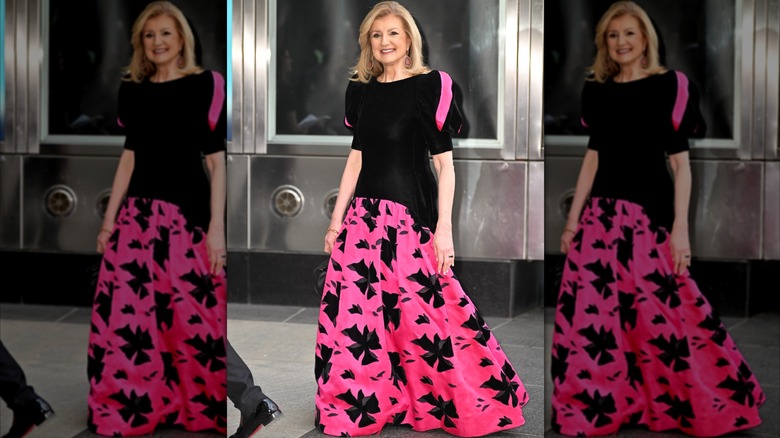 Arianna Huffington in pink and black dress with black pattern on pink skirt and puffy sleeves