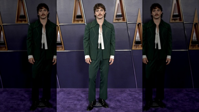 Benson Boone posing in green suit