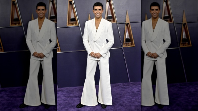 Ezra Sosa smiling in white bell-bottomed suit