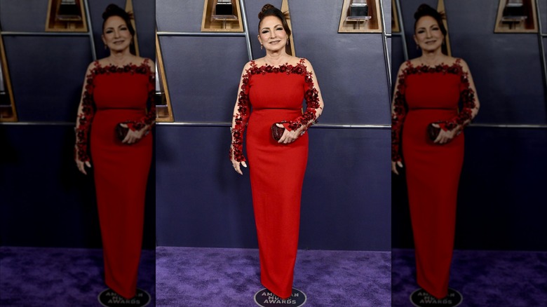 Gloria Estefan posing in a red dress with glitter embellishments