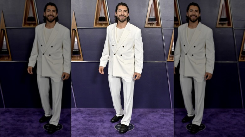 Jason Tartick posing in a white suit