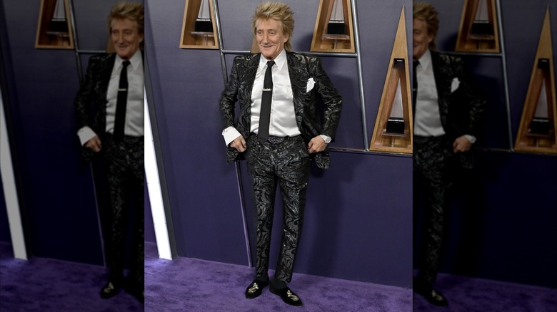 Rod Stewart posing in shiny black suit