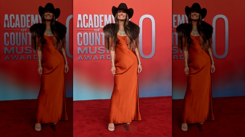 Annie Bosko posing in orange dress and fur stole