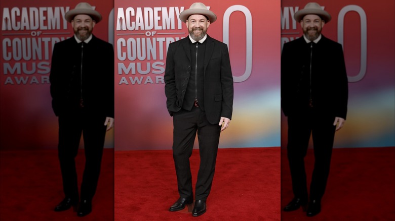 Kristian Bush posing in black suit and tan hat