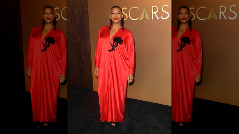 Queen Latifah in a red dress, beaming on the red carpet for the Governors Awards.