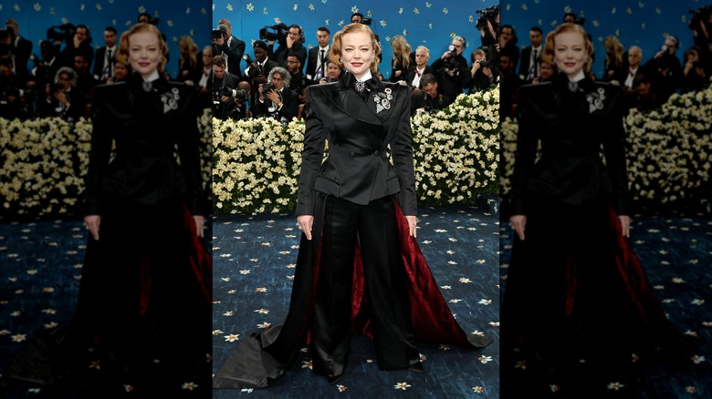 Sarah Snook posing in a black suit with a cape