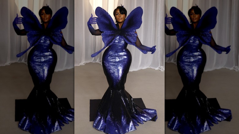 Janelle Monáe poses in a purple butterfly gown