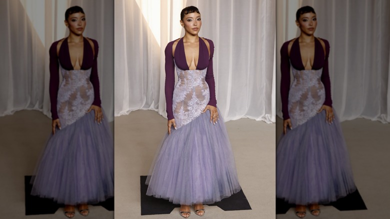 Tinashe poses for the camera in a purple dress