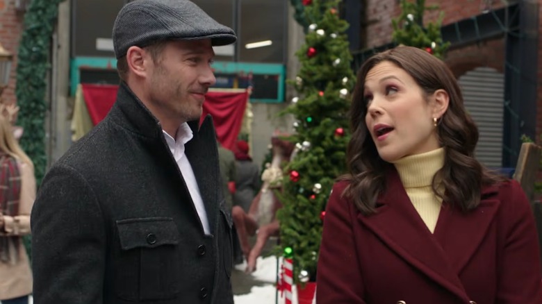 Erin Krakow and Luke Macfarlane talking to each other in coats