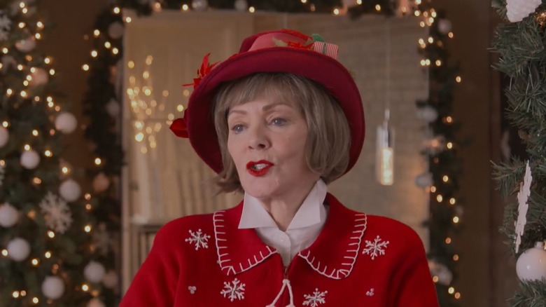 Jean Smart talking in front of a Christmas tree in a holiday-themed outfit