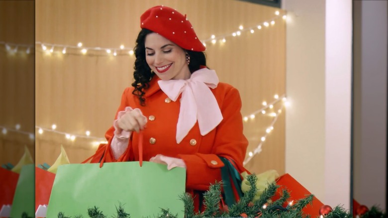 Meghan Ory smiling while looking through a shopping bag
