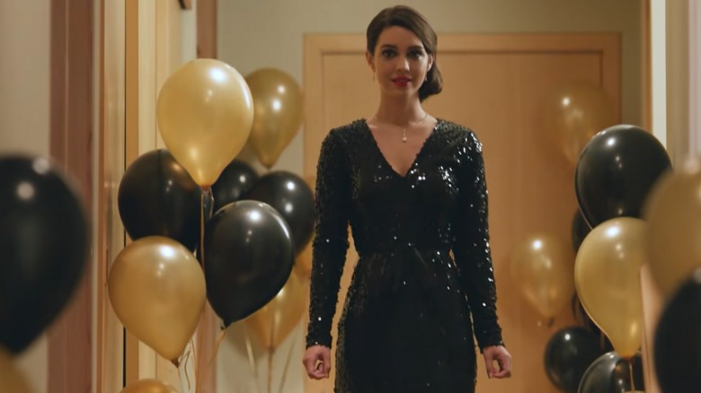 Adelaide Kane smiling in a sparkly dress, surrounded by balloons