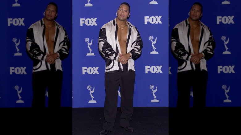 Dwayne Johnson in a white button-down shirt and black pants