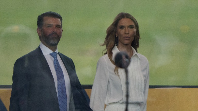 Donald Trump Jr. walking on stage with Bettina Anderson at 2025 military parade