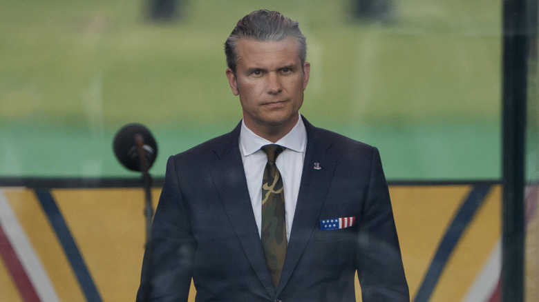 Pete Hegseth wearing a camo tie on stage at 2025 military parade