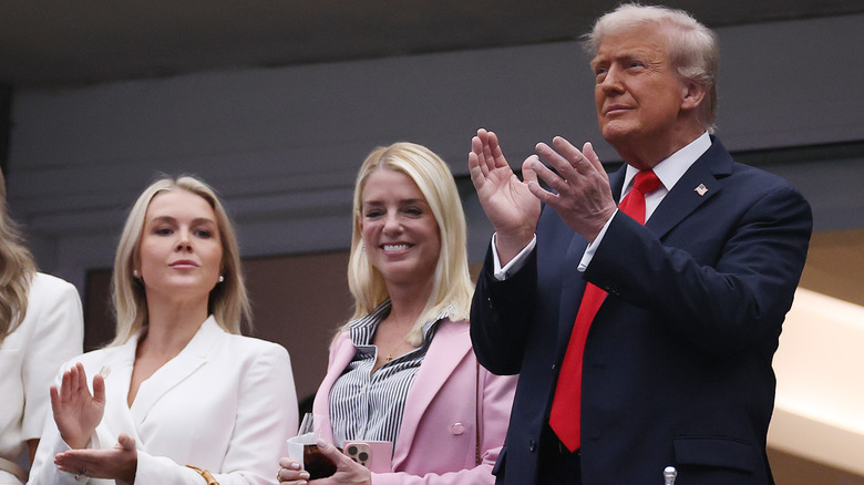 Donald Trump clapping beside Pam Bondi and Karoline Leavitt at the 2025 US Open.