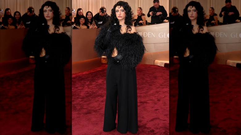 Odessa A'zion wearing black pants with black gloves and a black feathered jacket