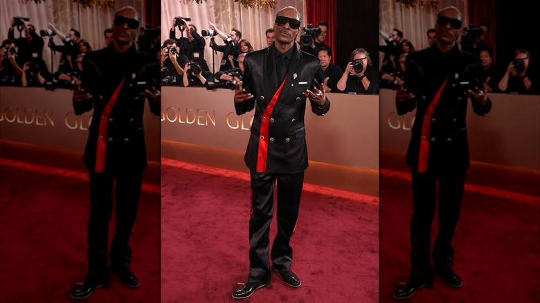 Snoop Dogg wearing a black suit with gold buttons and red detailing