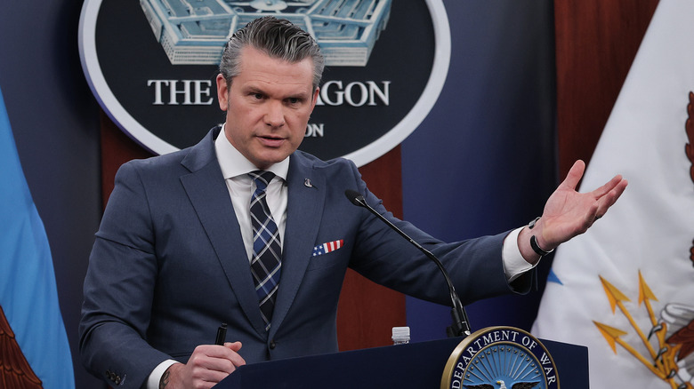 Pete Hegseth speaking at a podium during a press event