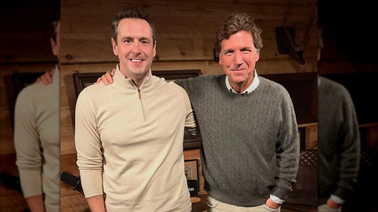 Zach Lahn and Tucker Carlson smile for a photo with their arms around each other's shoulders